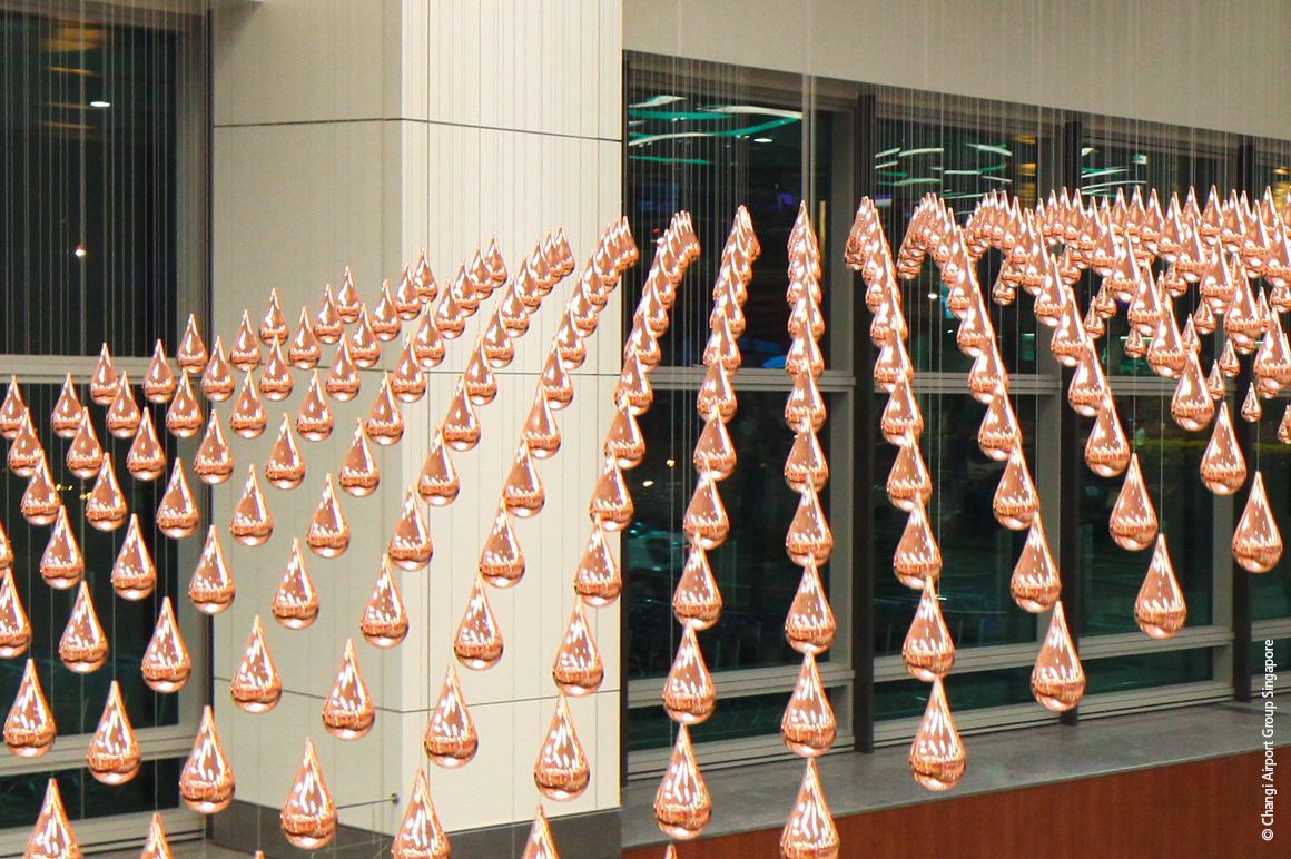 Mit „Kinetic Rain“ wurde am Changi Airport eine kinetische Skulptur, bestehend aus 1.216 hochglänzenden, verkupferten Aluminiumtropfen, realisiert, die synchron zu verschiedenen Schaubildern verfahren werden. © Changi Airport Group Singapore