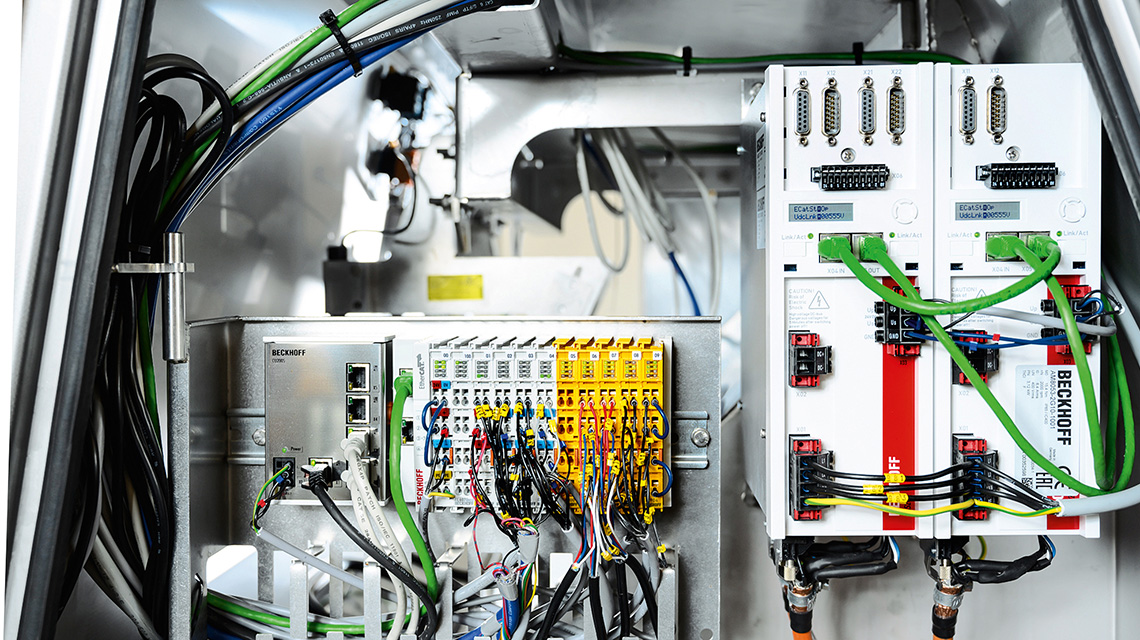 The EtherCAT and TwinSAFE terminals (center) and the AX5000 Servo Drives (right) enable a compact control technology design with minimum cabling effort, largely through the One Cable Technoloy used for the drive technology. 