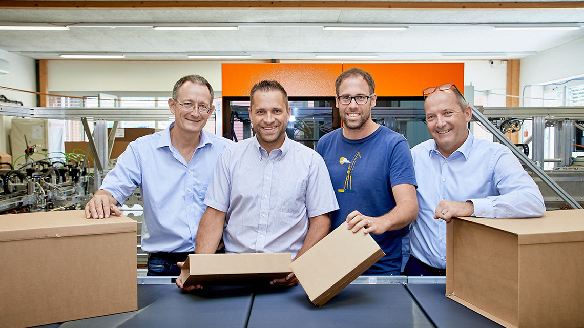 Marcel Stalder, Head of Development, Reto Schori, Subproject Manager Electronics, and Patrick Vogel, Project Manager PackOnTime®, all from Kern AG, and Andreas Iseli, Head of the Beckhoff Lyssach office, in front of the prototype of the Pack-on-Time system (from left to right). 