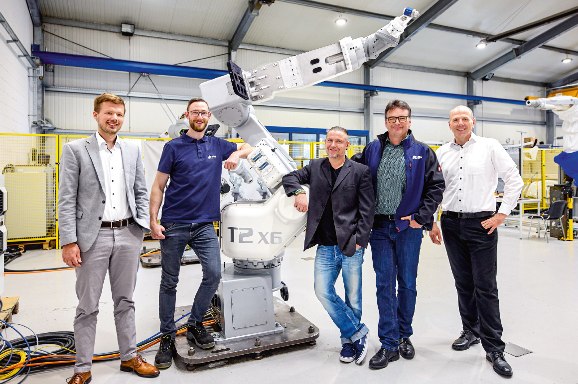 Die Roboterexperten von b+m rund um Bernd Käsmann (2.v.r.) neben dem Lackierroboter T2 X6 und zwischen Andres Oetken (l.), Beckhoff Branchenmanagement Prozessindustrie, und Michael Heumüller (r.), Beckhoff Vertriebsbüro Fulda